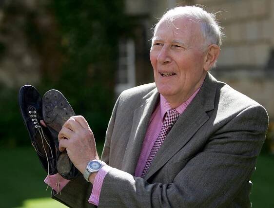 Sir Roger Bannister holds the running shoes he wore when he ran the first sub-four-minute mile in 19..