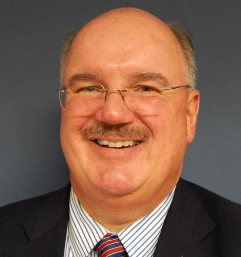 A man with glasses and a suit on.