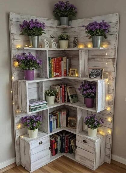 a book shelf with flowers and books on it in front of a wall filled with lights