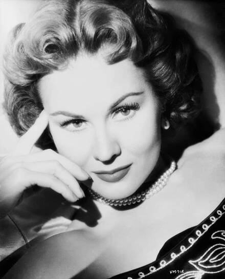 Virginia Mayo wearing a beaded top and pearl necklace, 1955.