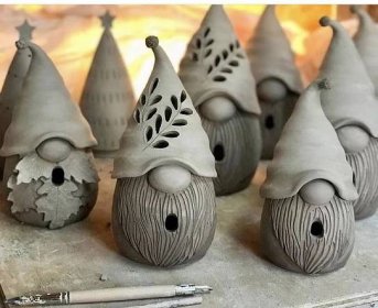 several clay garden gnomes sitting next to each other on a table with a pencil in front of them