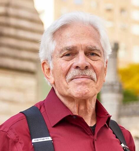 Participant Al - person with short white hair and a red shirt standing outside