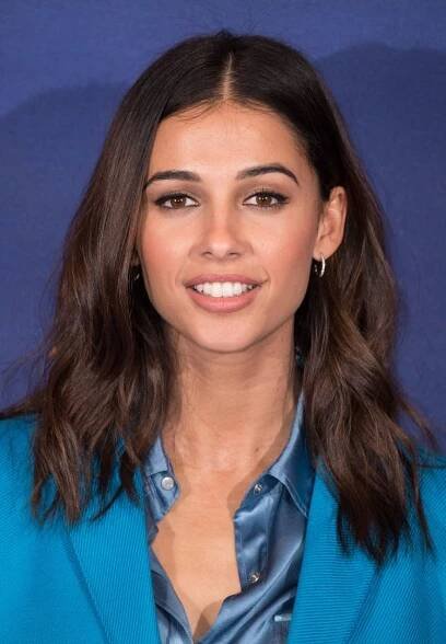 Naomi Scott wearing shoulder-length hair that's parted in the middle