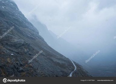 Download - Rocky mountainside with road and mist. Distant. Panoramic. — Stock Image