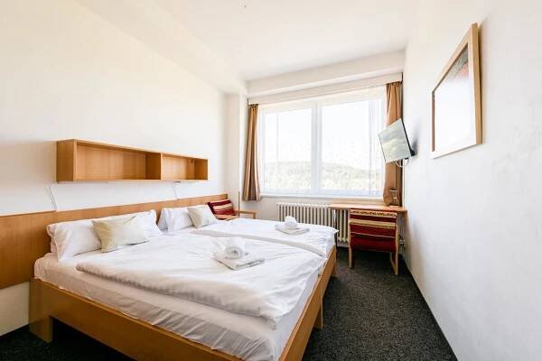 a hotel room with a bed and a window at HOTEL AGRI in Soběšice