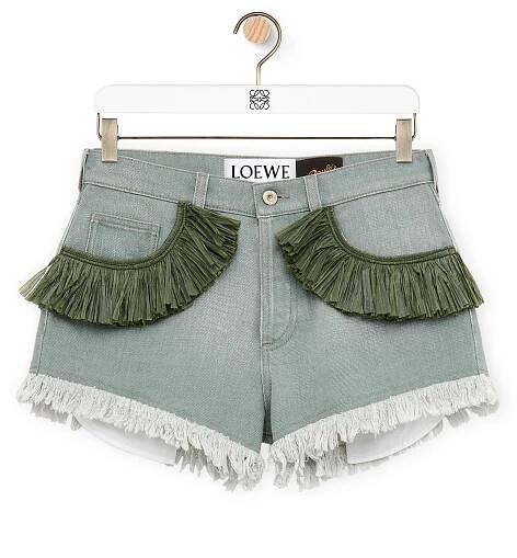 A pair of khaki green, fringe denim shorts priced at $990.00