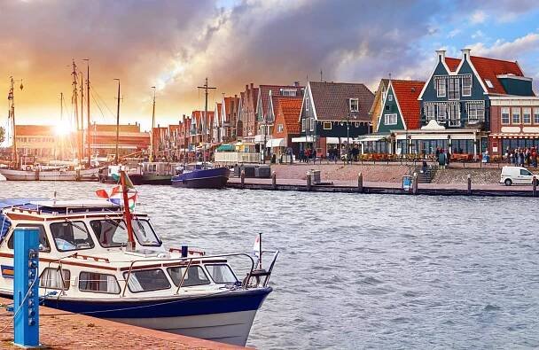 Volendam, Nizozemsko. Luxusní jachta zaparkovaná u mola při západu slunce stock fotka