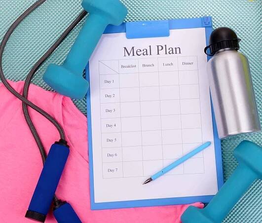 Meal plan and sports equipment top view close-up — Stock Image