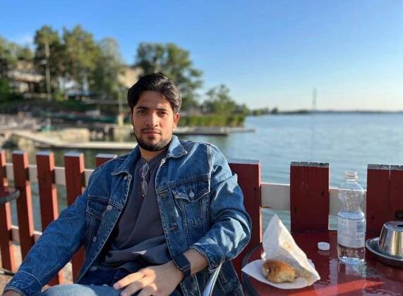 Jorge Reyes, a man sat outside at a table near the water.