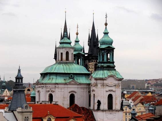 Praha. Barokní kostel svatého Mikuláše, za ním gotický Týnský chrám a vpravo za nimi funkcionalistický Dům odborových svazů. Fotografováno ze střechy domu Kaprova 10.
