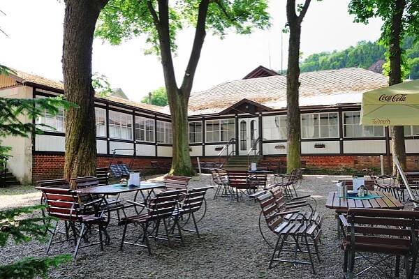 a group of tables and chairs in front of a building at Hotel Praha Potštejn in Potštejn