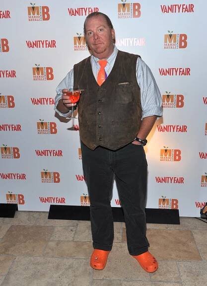 Mario Batali holding up a cocktail. 