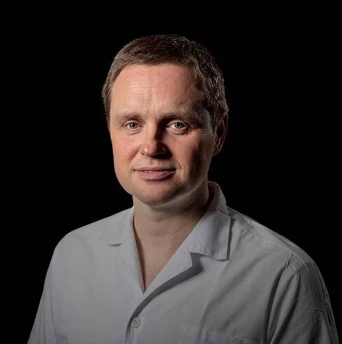 portrétní fotka Jiřího Dostála na černém pozadí