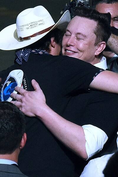 Elon Musk embraces his brother Kimbal Musk following the successful launch of a Falcon 9 rocket at the Kennedy Space Center.