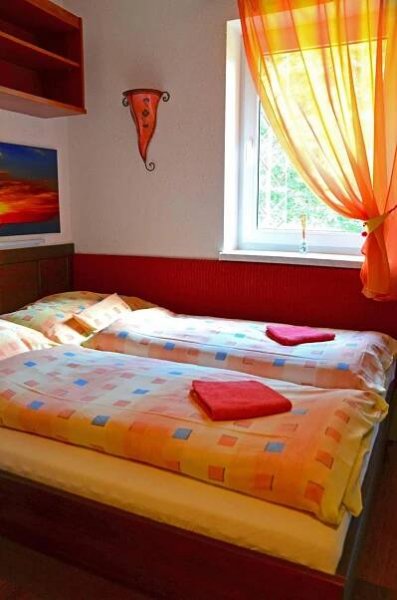 two beds in a bedroom with a window at Penzion Pod Boubínem in Kubova Huť
