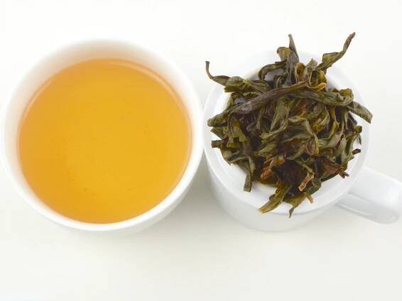 Cupped infusion of Yu Lan Xiang (Magnolia) wulong tea and strained leaves.
