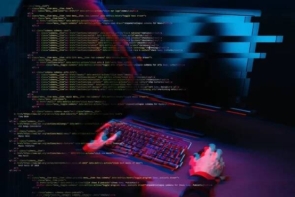 Hacker pracující s počítačem v tmavé místnosti s digitálním rozhraním v okolí. Obrázek s efektem efektu. — Stock obrázek