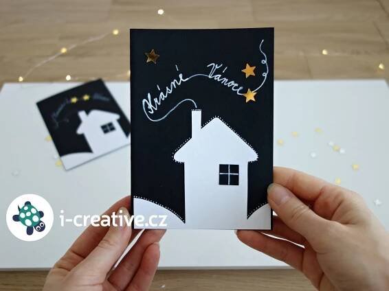 someone is holding up a card with a house and stars in the sky on it
