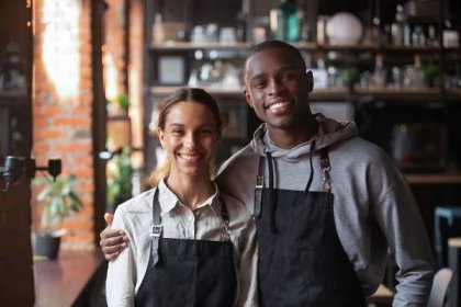 šťastný rozmanitý číšník a servírka při pohledu na kameru v restauraci - black small business owner - stock snímky, obrázky a fotky