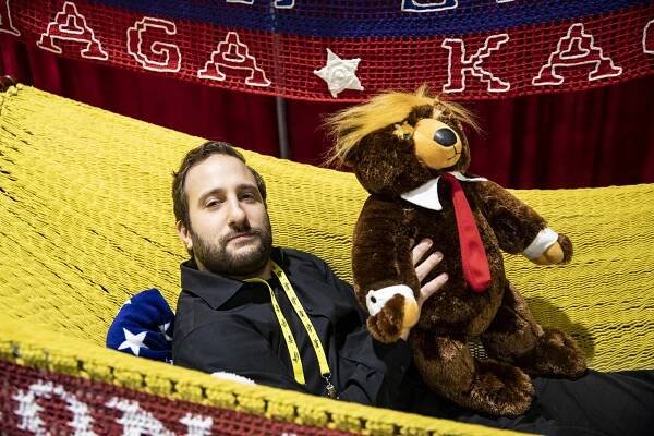 New York Post reporter Jon Levine lays in a President Trump themed hammock while holding a Trump themed teddy bear that are for sale at the Conservative Political Action Conference.