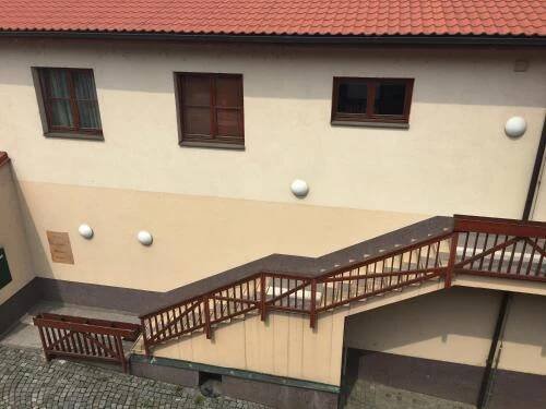 a building with a staircase and two benches in front at Kounický dvůr in Dolní Kounice