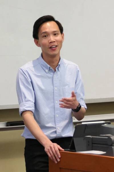 Nicholas Eng stands at a lectern in class.