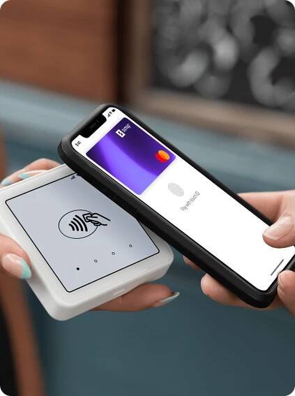 Person making a contactless payment with SumUp Pay on a smartphone, held near a SumUp card reader.