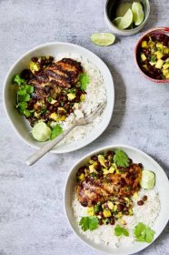 Two servings of Caribbean Jerk Chicken with Mango Black Bean Salsa with rice in white bowls.