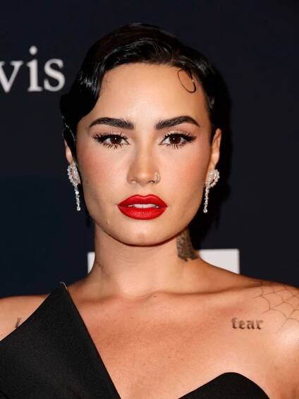 Demi Lovato in a black asymmetrical gown with a bold red lip and tapered brows - InStyle Brow Shapes