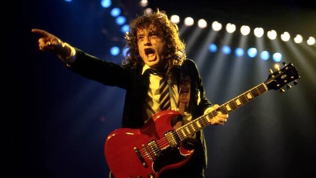 DETROIT - NOVEMBER 17: Angus Young, lead guitarist for AC/DC, wearing his iconic British schoolboy uniform and playing his red Gibson SG, performs during the Flick of the Switch/Monsters of Rock tour, on November 17, 1983, in Detroit, Michigan. (Photo by Ross Marino/Rock Negatives) /IPX