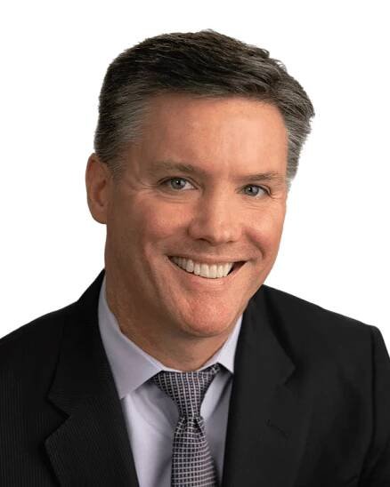A man in a suit and tie smiling.