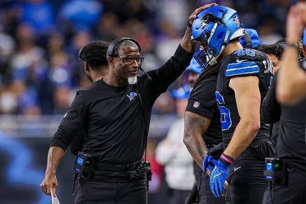 Aaron Glenn talks with Jack Campbell during a Lions game in December 2024.