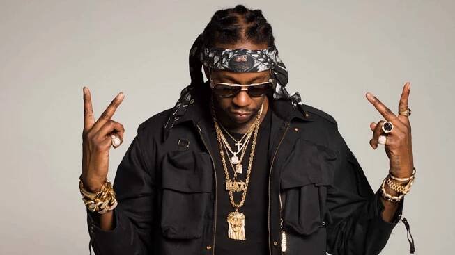 A Man With A Black Jacket And Gold Chains