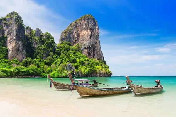Small canoe boats sit on beach in Thailand