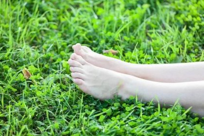 Bosý atraktivní ženské nohy v zelené trávě — Stock obrázek