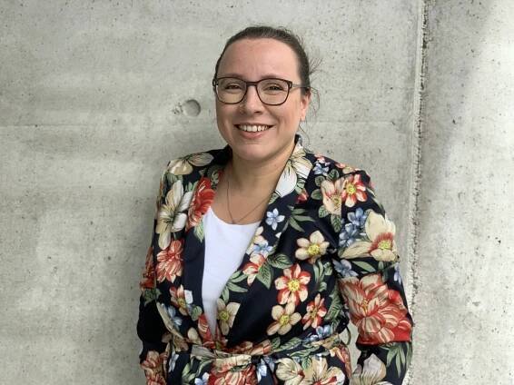 Portraitfoto von Ana Fernandes-Mühl. Sie blickt direkt in die Kamera und trägt eine Bluse mit Blumenmuster.