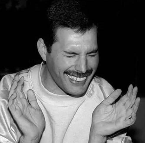 black and white photograph of a man with his hands in front of him, smiling