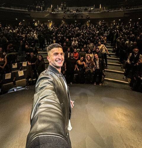 Sahil Bloom on stage selfie with the audience.