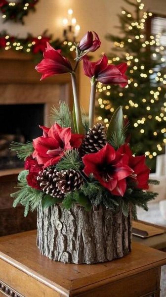 a christmas centerpiece with red flowers and pine cones