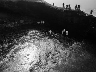 A crew helps clean up a massive oil spill in the seas of Peru.
