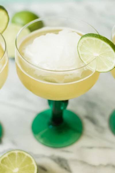 frozen beergarita in a cocktail glass with a lime garnish