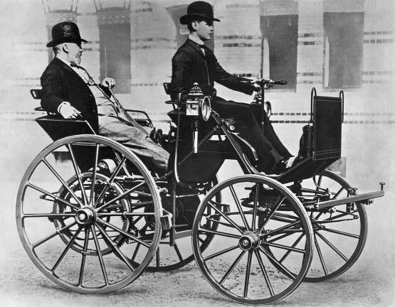 Gottlieb Daimler als Passagier in seiner Motorkutsche aus dem Jahr 1886. Am Steuer sein Sohn Adolf. (Fotosignatur der Mercedes-Benz Classic Archive: C23227)