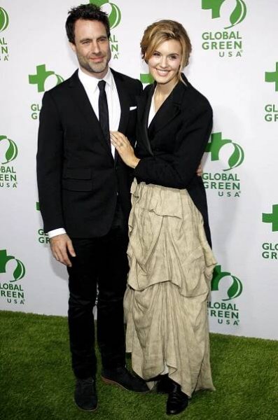Matthew Cooke towers over Maggie Grace, who pairs a dramatic draped beige skirt with a structured black blazer and heeled boots at Global Green USA’s 12th Annual Pre-Oscar Party, held at Avalon Hollywood on February 18, 2015