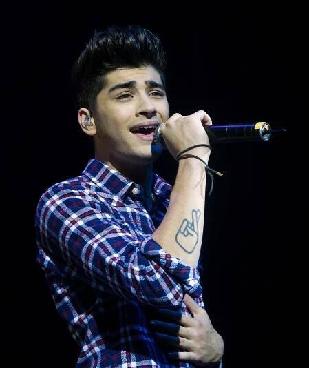 Zayn Malik of One Direction performing on stage.