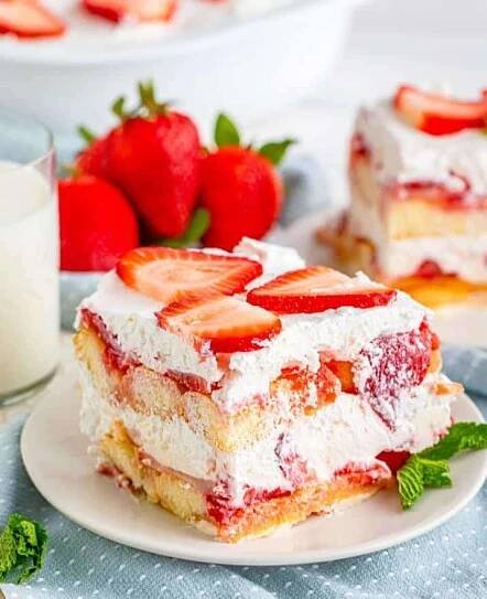 Tiramisu se šlehačkou a čerstvými jahodami na talířku.