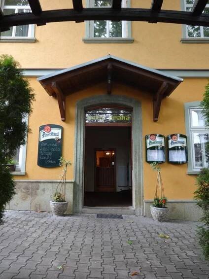 an entrance to a building with a yellow wall at Hotel Praha Potštejn in Potštejn