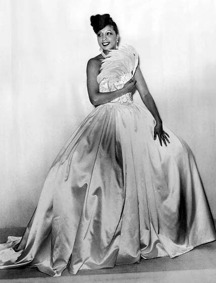 Actress Josephine Baker in evening gown and fan made of feathers
