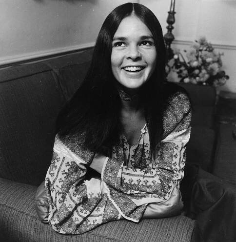 Image may contain Furniture Couch Ali MacGraw Face Human Person Clothing Apparel Smile and Female