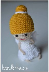 a small crocheted doll with a yellow hat