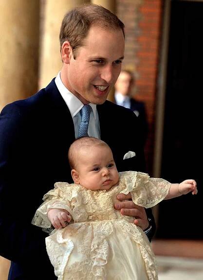Prince William, Duke of Cambridge arrives, holding his son Prince George, at Chapel Royal in St James's Palace, ahead of the christening of the three month-old Prince George of Cambridge